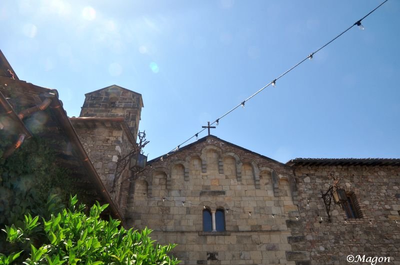 Castello Di Amorosa: каменная арка с крестом под ясным небом